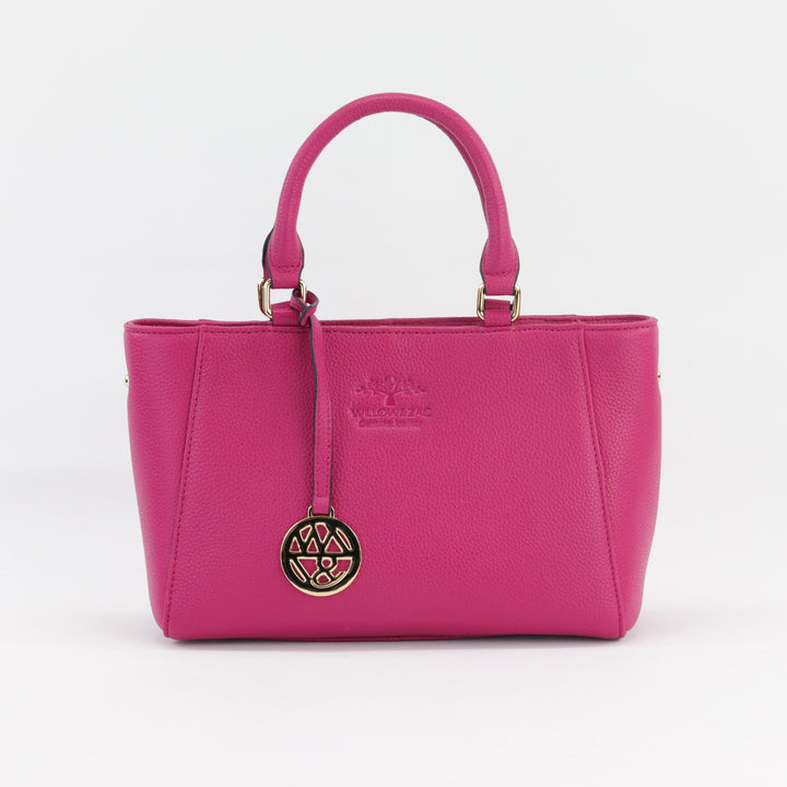 front view of compact fuchsia leather handbag with padded handles and removable logo charm#colour_fuchsia