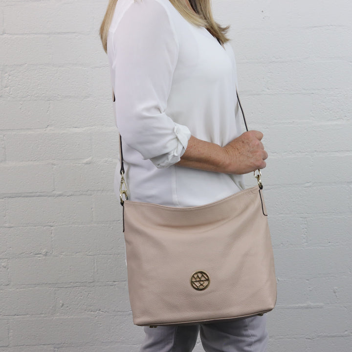 lady wearing nude leather amber hobo bag in crossbody#colour_nude