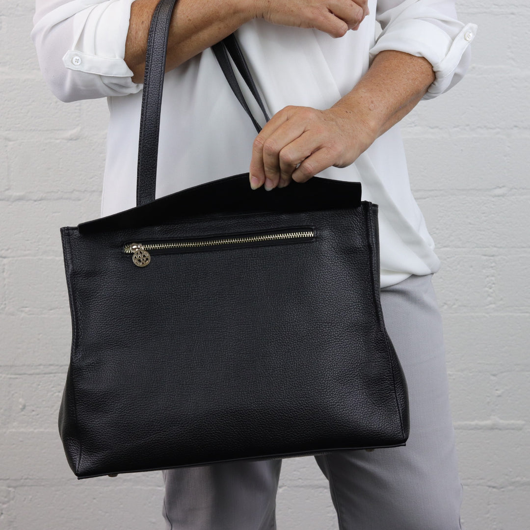 woman model reaching into hidden zippered pocket on eleanor tote bag#colour_black-with-black-cosmos