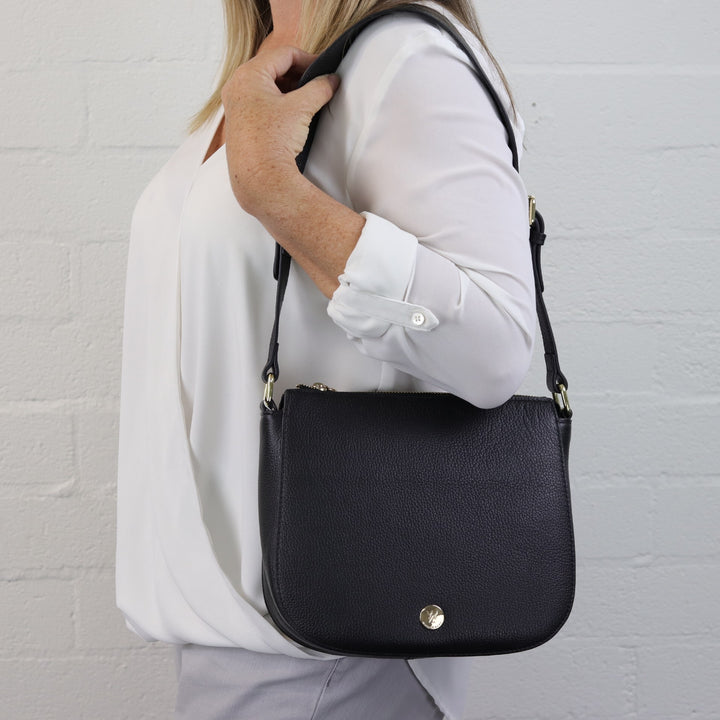 leather black structured curved bottom bag with wide leather shoulder strap#colour_black