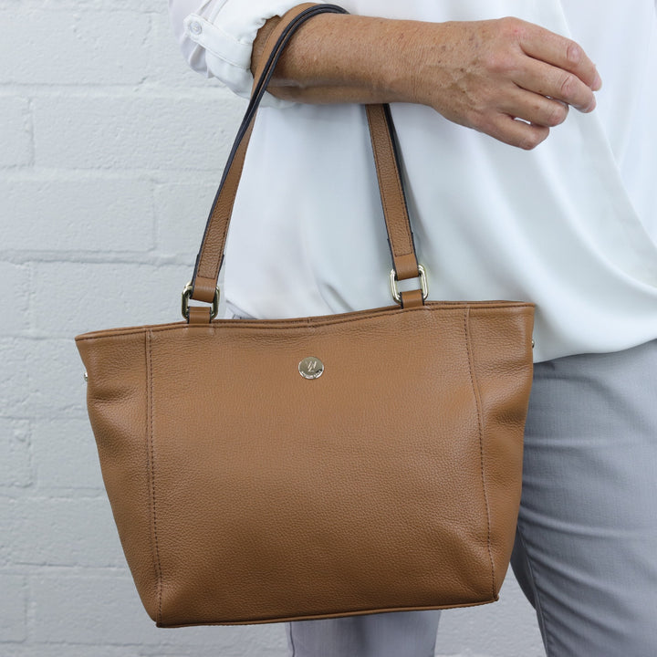 tan caramel coloured leather tote worn on the arm of woman model#colour_caramel-leather