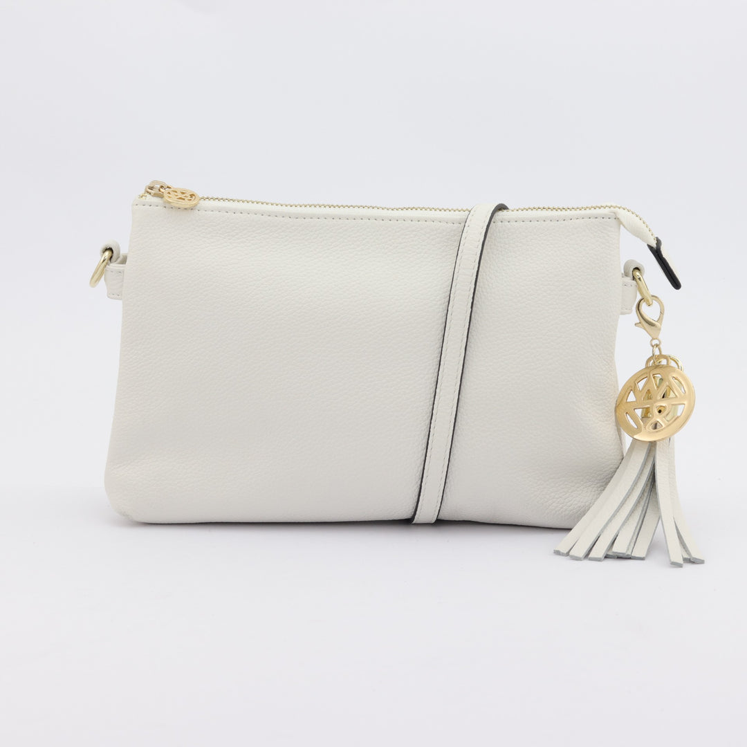 ruby clutch or crossbody handbag in white pebbled leather with gold badge and tassel#colour_white