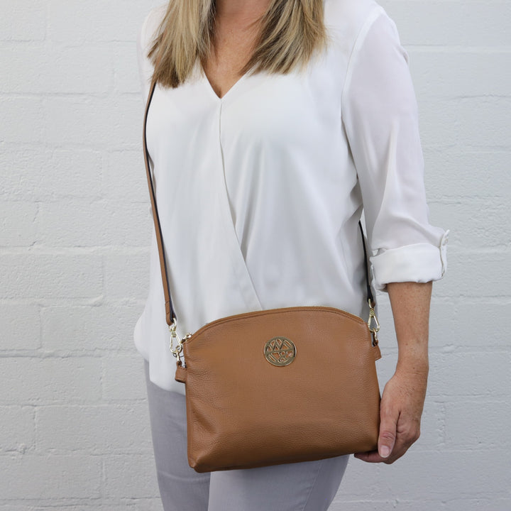 model wearing caramel tan coloured bag as a crossbody style with long adjustable strap