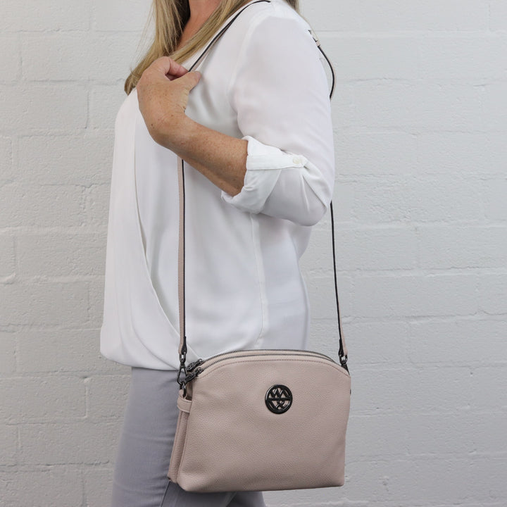 lady wearing nude handbag with black hardware on shoulder#colour_nude-black-hardware