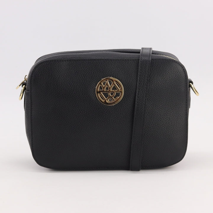 camera bag style bag in black pebbled leather with gold badge logo and long adjustable strap#colour_black