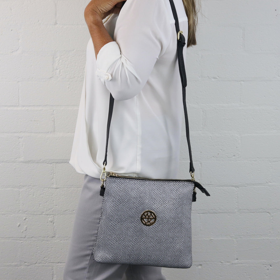 model wearing square zippered handbag in white and black printed suede#colour_white-black