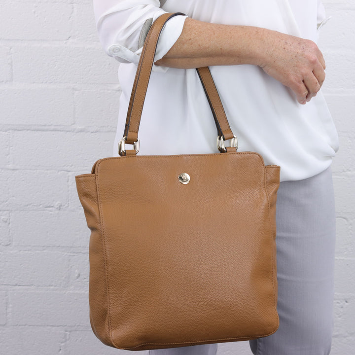 caramel tan large leather totewith double handles worn on arm my woman model