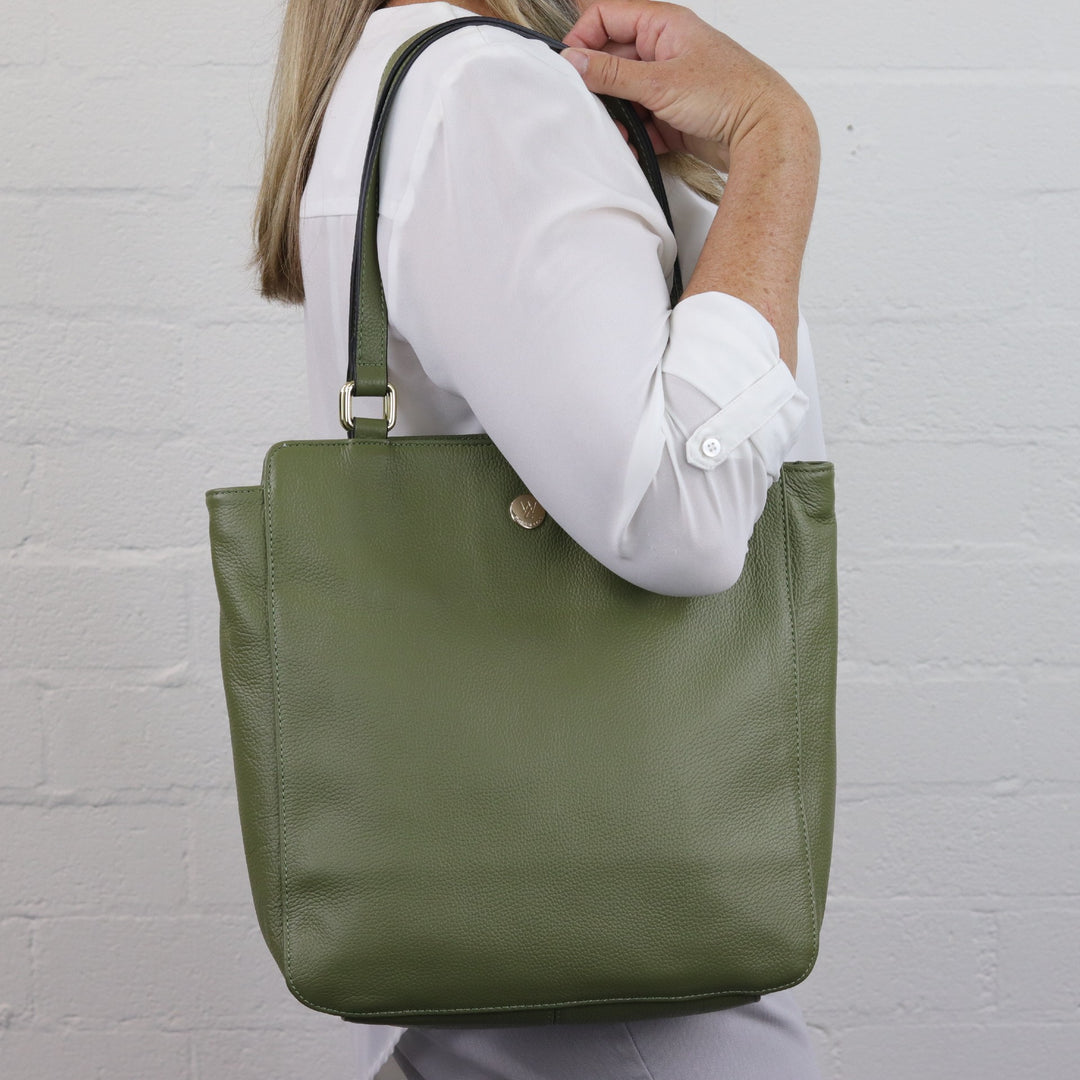 woman wearing katrina portrait style tote on shoulder with leather handles and gold hardware