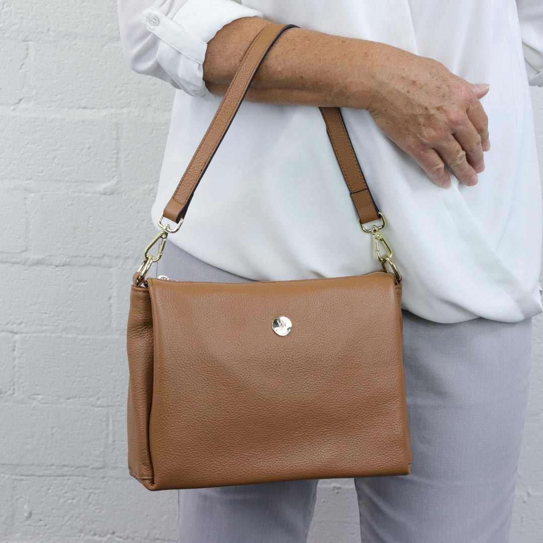 lady wearing nina tan caramel handbag on arm with short strap attached #colour_caramel