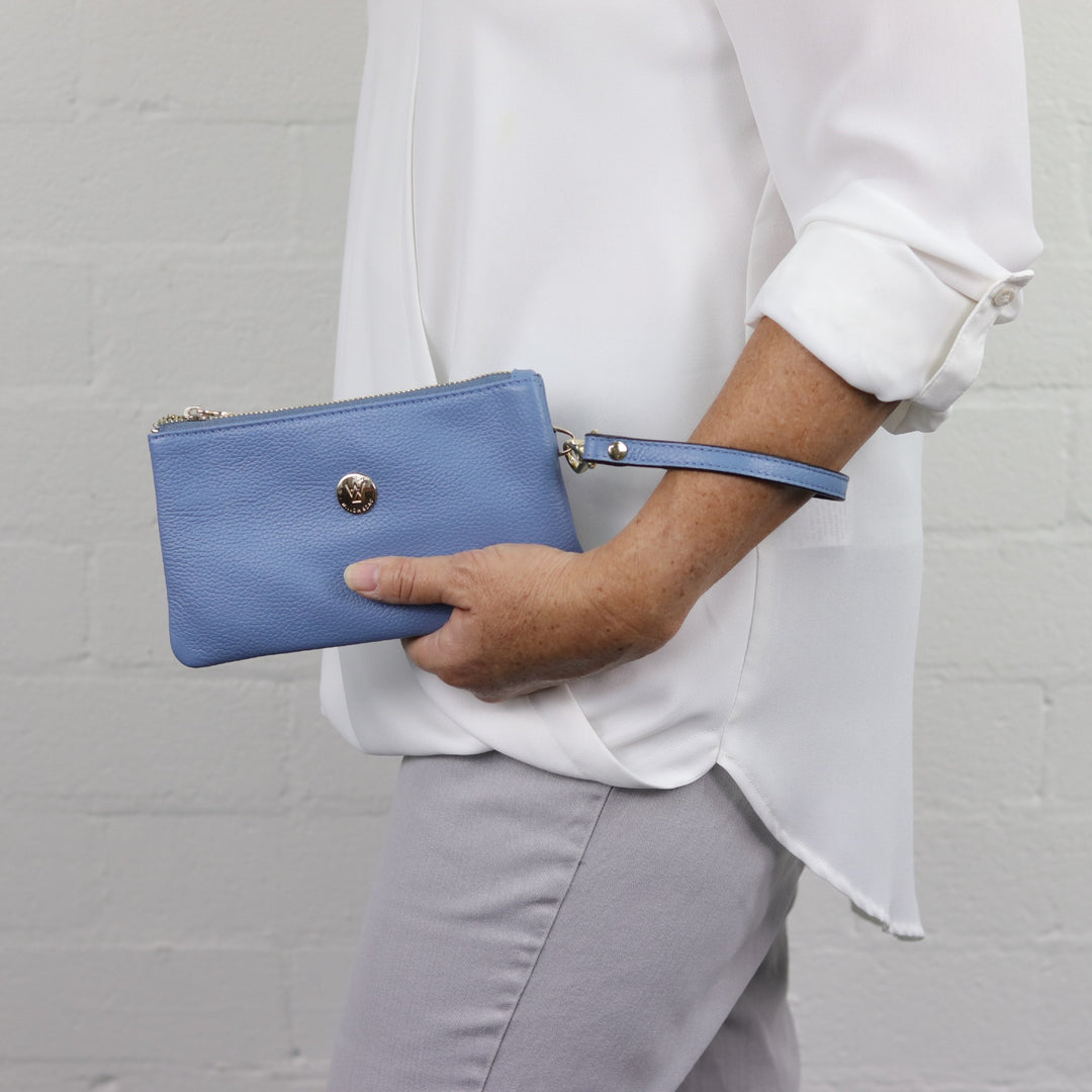 blue coloured leather wristlet with wrist strap and gold hardware#colour_serene-blue