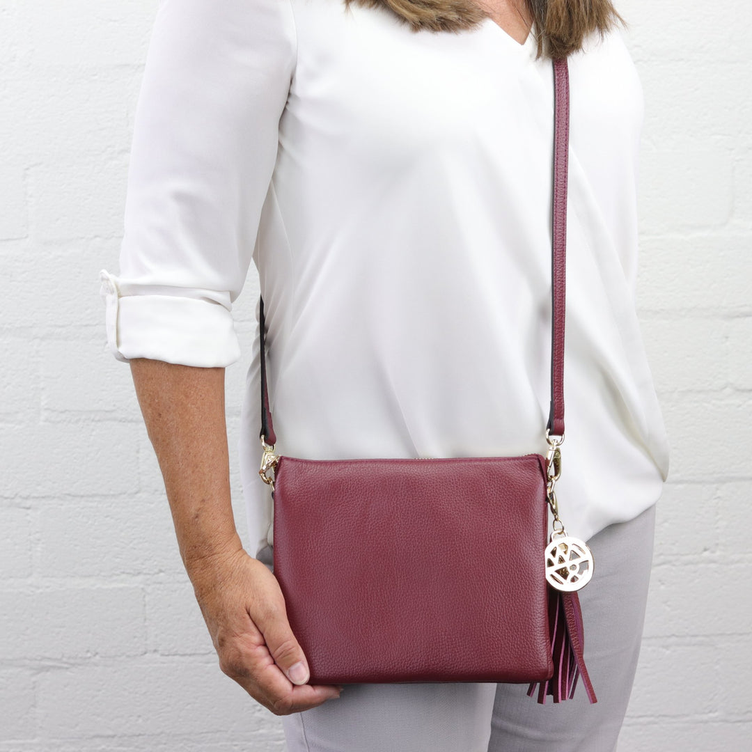 square shaped tara handbag  in maroon pebbled leather being worn by woman model  #colour_shiraz